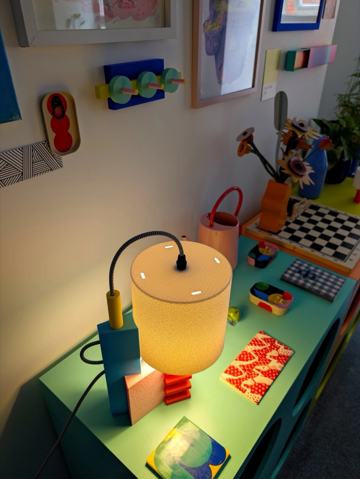 The "Memphis Is Back" lamp switched on, its cross-hatched internal infill pattern glowing visibly through the shade