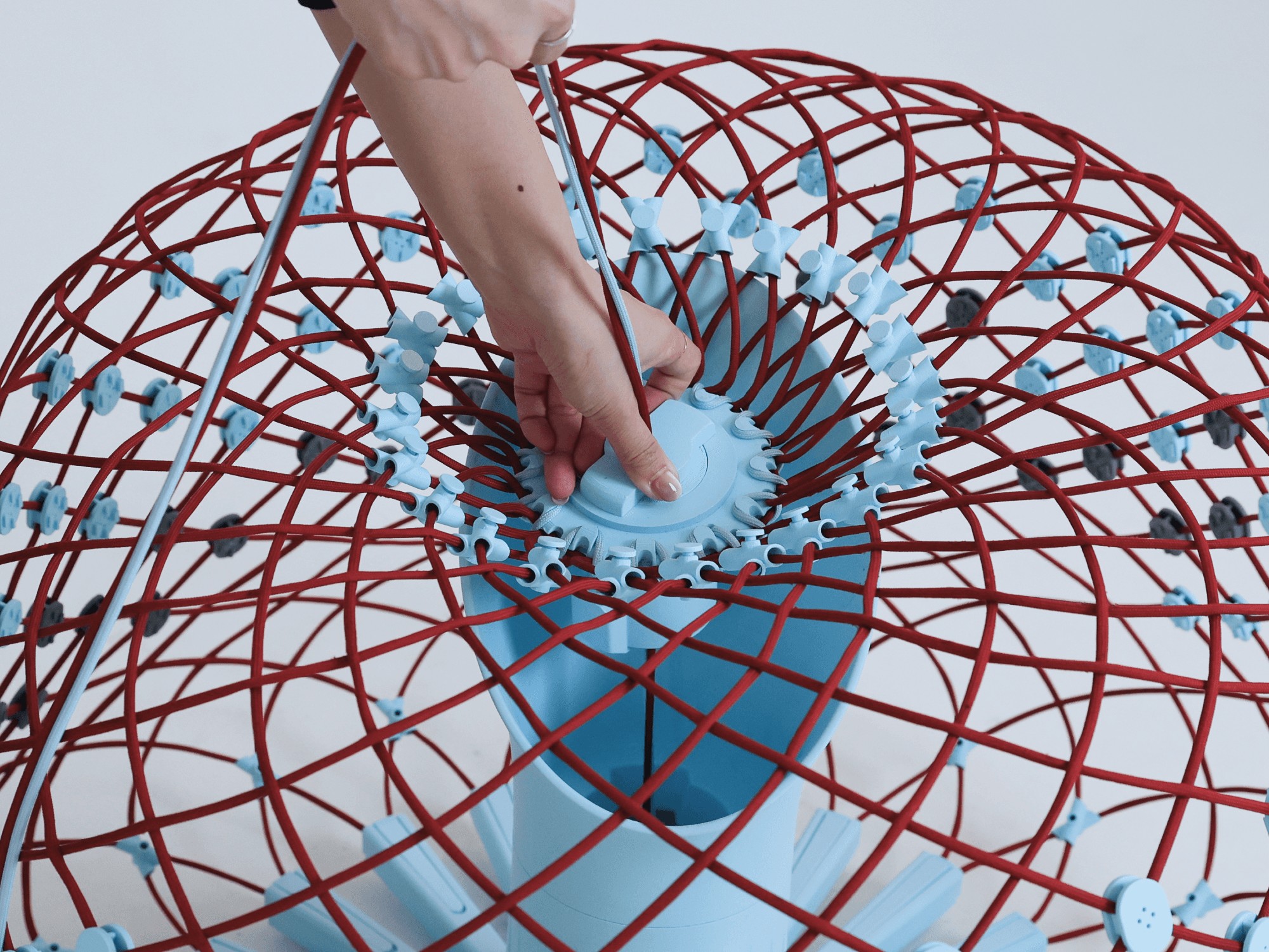 A close-up of the central hub that manages tension across the sofa's woven nitinol-and-cord structure