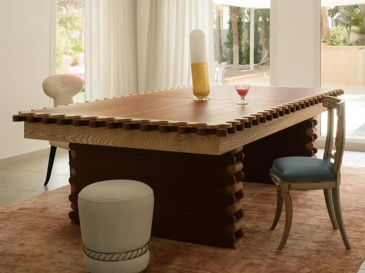 The Sanne's 3-in-1 Table set up in its dining configuration, a mid-century-style wood table with a scalloped edge in a bright living room