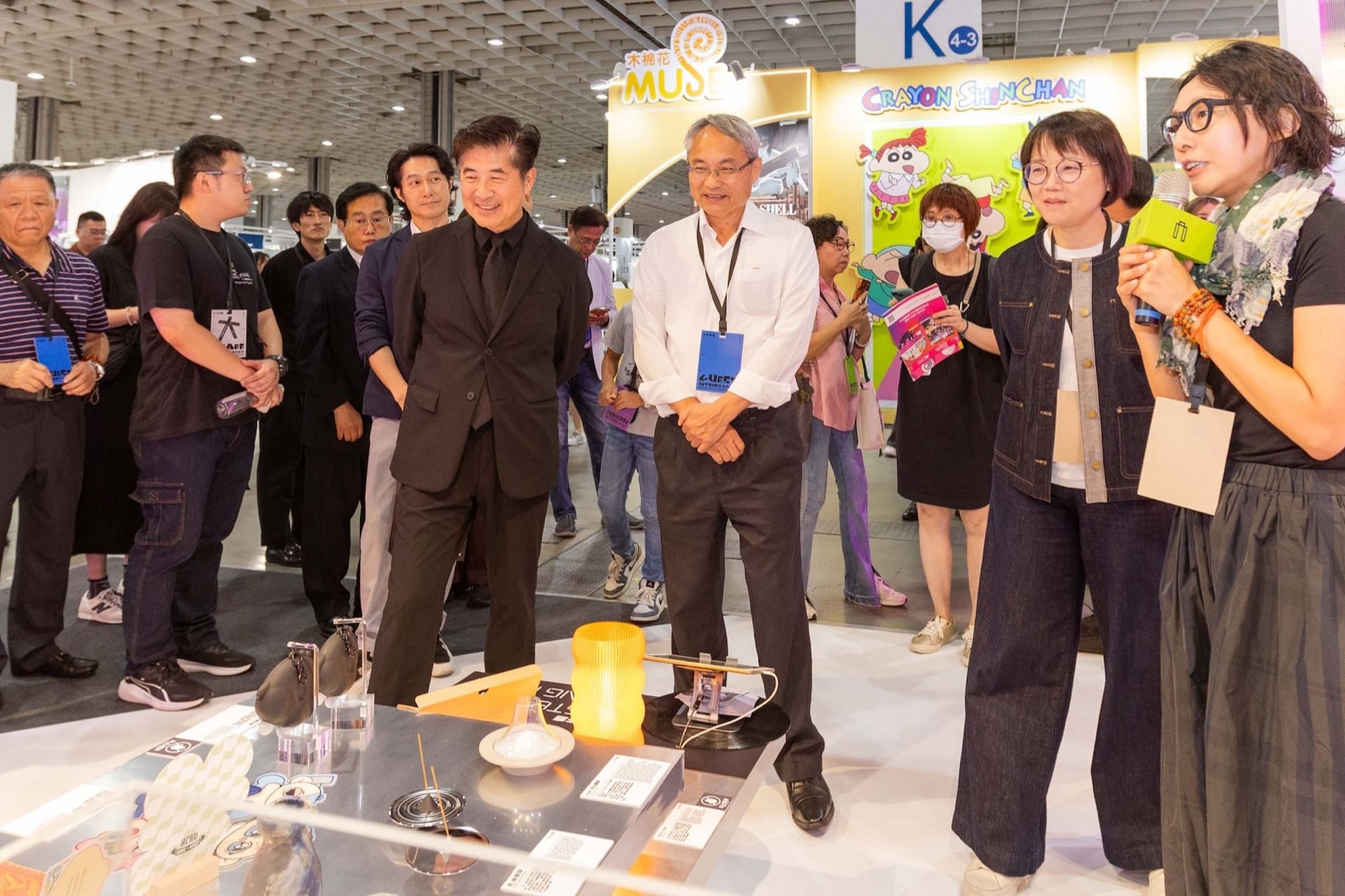 Visitors examining brand products, including an incense holder and candle stand, at the Taiwan Creative Expo's brand exhibition
