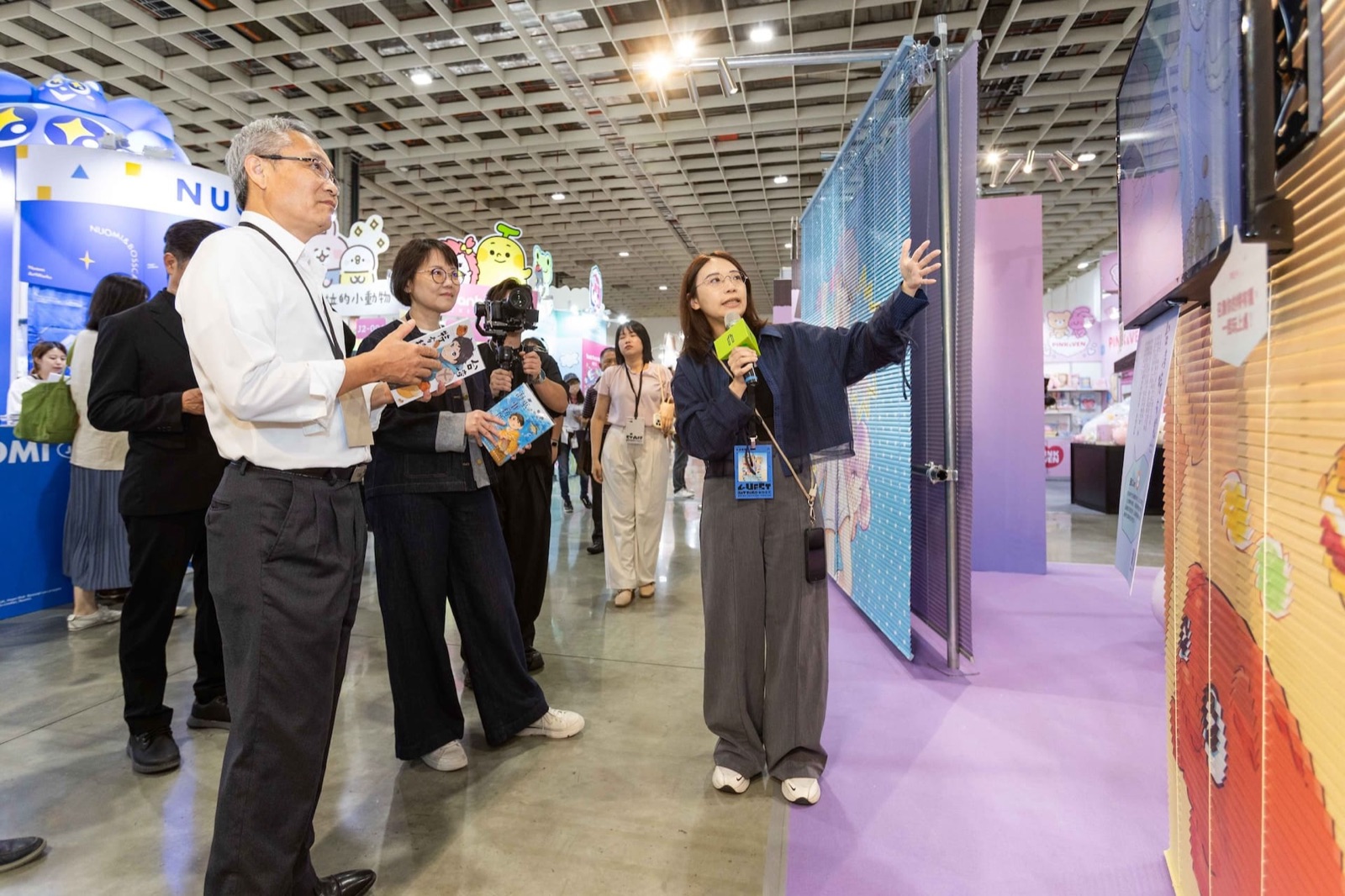 Attendees walking through the Taiwan Creative Expo's exhibition space, viewing a colorful installation panel