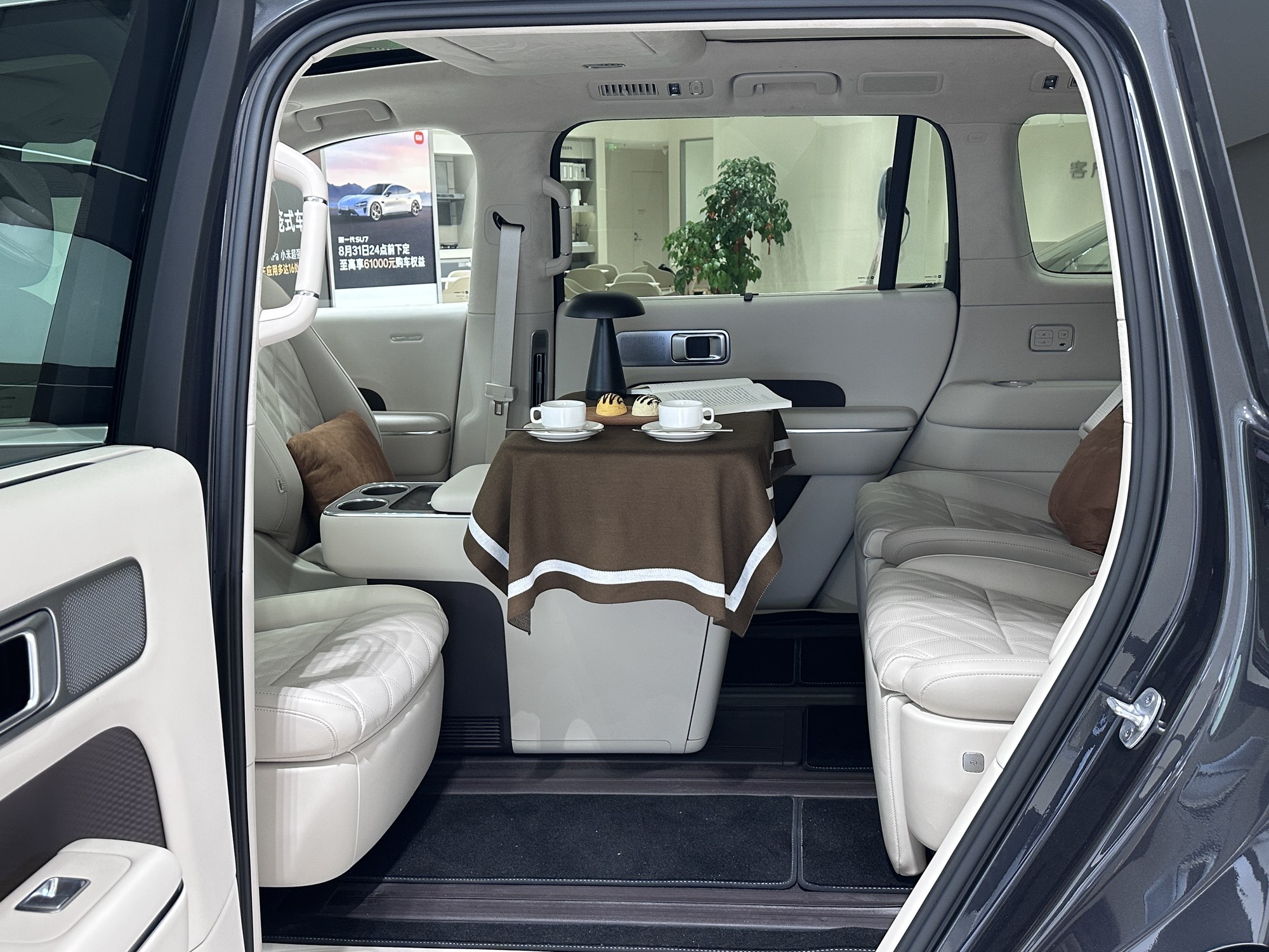 The SkyNomad N90 Max's rear cabin with seats rotated to face a table mounted in the floor track, set for tea